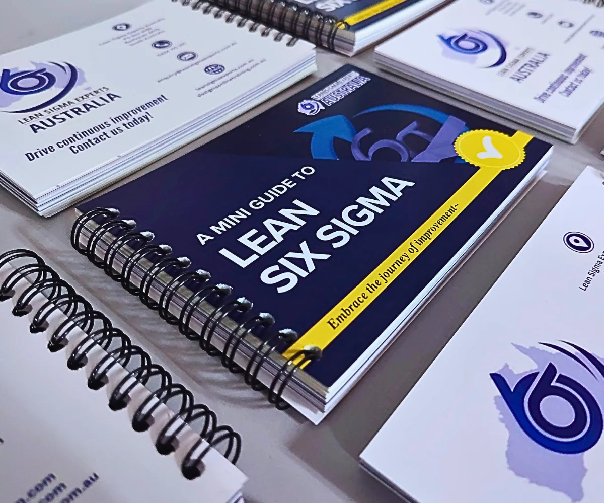Printed copies of A Mini Guide to Lean Six Sigma pocket guide on a desk